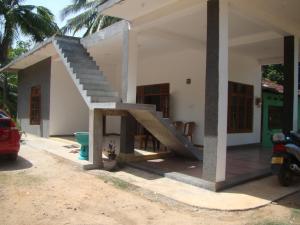 a house with a staircase on the side of it at Priyanna Guest, Forest view in Polonnaruwa