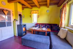 a living room with a couch and a table and a stove at Domceky Holiday in Liptovský Trnovec