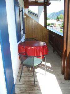 een tafel en stoel op een balkon met een raam bij Familie Gerle in Vils