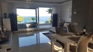 Sala de estar con mesa y vistas al océano en Horizon Beach Apartment, en Estepona