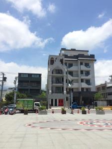 a large white building in a parking lot at Angel Wings Inn in Hualien City