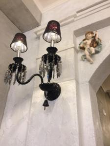 two lights on a wall with a doll on a ledge at Angel Wings Inn in Hualien City