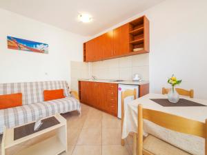 a kitchen and a living room with a table and a couch at Apartment Orange in Petrovac na Moru