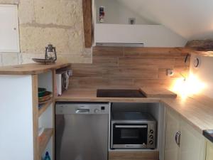 a kitchen with a stove and a microwave at studio avec terrasse Abbaye d'Aiguevive in Faverolles-sur-Cher