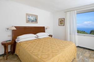 a bedroom with a bed and a large window at Hotel Bellavista in Anacapri