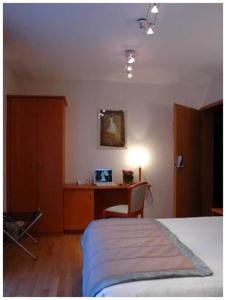 een slaapkamer met een bed en een bureau. bij Hotel South Charleroi Airport in Charleroi