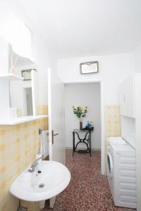 a bathroom with a sink and a washing machine at Old SALONA in Solin +9 photos