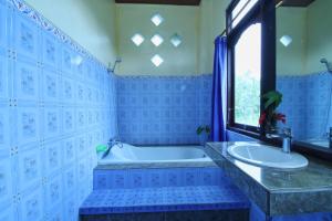 a bathroom with a tub and a sink at Suwar Bungalows in Ubud