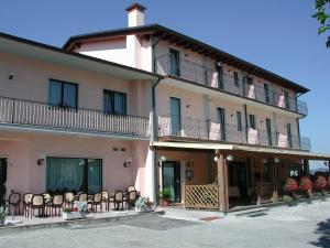 un edificio con sillas y mesas delante de él en Hotel Ristorante Pedrocchi, en San Giorgio di Perlena