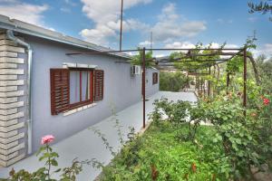 a white house with a window and a garden at Old SALONA in Solin