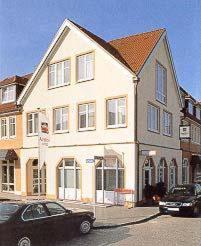 une maison blanche avec une voiture garée devant elle dans l'établissement Andersen Hotel Schwedt, à Schwedt-sur-Oder