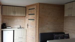 スロースケルケにあるzeeuwse chalet voor 2 personenの木製の壁の客室とシンク付きのキッチンが備わります。