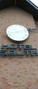 a clock on the side of a brick building at Hotel South Charleroi Airport in Charleroi