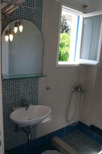 a bathroom with a sink and a mirror and a window at Hotel Minoa in Katapola