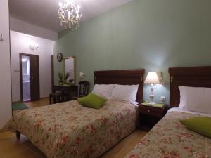 a bedroom with two beds and a chandelier at Akrotiri Hotel in Neos Marmaras