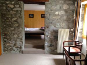 une chambre avec un mur en pierre et une chambre avec un lit dans l'établissement Hotel de la Sage, à La Sage