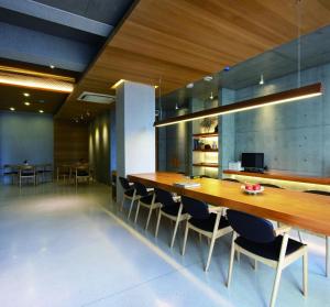 una sala da pranzo con un grande tavolo in legno e sedie di Wood Whispering Residence a Tainan