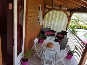 a patio with a table and chairs on a porch at Gîtes Soussoune in Anse-Bertrand