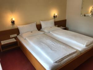 A bed or beds in a room at Gasthof Sprenger