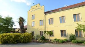 żółty budynek z znakiem na boku w obiekcie Relax Hotel Stork w mieście Lednice