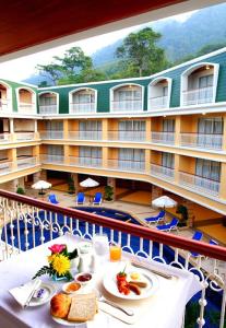 un balcón con una mesa con comida y un hotel en Kalim Resort - SHA Plus, en Patong Beach