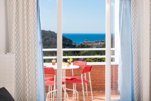 a table and chairs on a balcony with a view of the ocean at Apartaments Els Llorers in Lloret de Mar