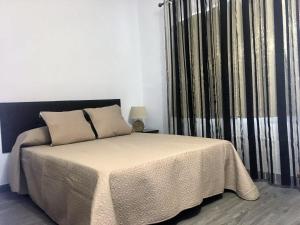 - une chambre avec un lit et une fenêtre avec des rideaux dans l'établissement Apartamento Cocoa, à Oropesa del Mar