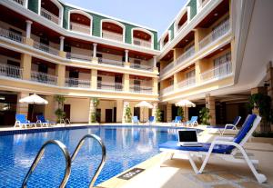巴東海灘的住宿－Kalim Resort - SHA Plus，酒店游泳池的椅子上摆放着笔记本电脑