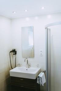 y baño con lavabo blanco y espejo. en Haus Rainbach, en Umhausen