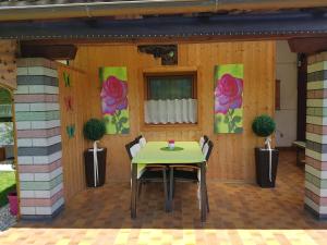une table et des chaises sur une terrasse avec des fleurs sur le mur dans l'établissement Haus Bodenwinkler, à Gröbming