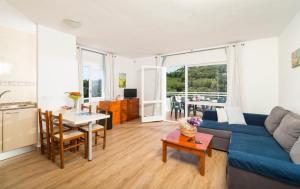 a living room with a blue couch and a table at Apartaments Els Llorers in Lloret de Mar
