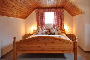 Schlafzimmer mit einem großen Holzbett und einem Fenster in der Unterkunft Feichterhof in Bad Kleinkirchheim