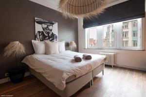 - une chambre avec un grand lit et des serviettes dans l'établissement Smartflats City - Manneken Pis, à Bruxelles