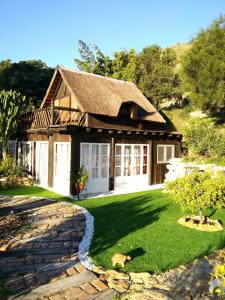 una casa con techo de paja y patio en El Jardín de las Hadas, en Turre