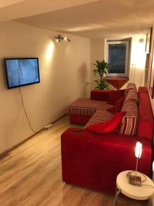 a living room with a red couch and a flat screen tv at Casa Magdalena Summer Home in Krk Old Town in Krk