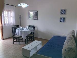 a dining room with a table and chairs and a bed at Platanos Apartment in Nea Moudania