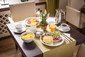 einen Tisch mit Teller mit Lebensmitteln und Obst darauf in der Unterkunft Das Frühstückshotel Sankt Peter-Ording in Sankt Peter-Ording