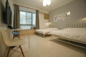 a bedroom with two beds and a desk and a tv at Cats in summer in Hengchun