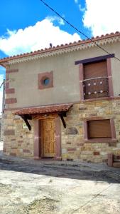Casa de piedra con puerta y ventana en Rural Las Campanas, en Torremocha del Pinar