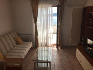 uma sala de estar com um sofá e uma mesa de café em vidro em Apartments Marija em Sveti Petar