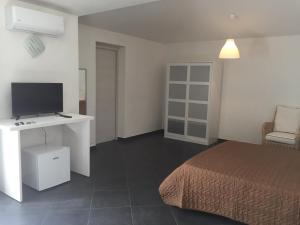 a bedroom with a bed and a desk with a television at Guest House Suite in Olbia