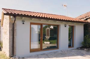 a house with sliding glass doors on it at Galpon Boutique Aldea De Abaixo in Palas de Rei 
