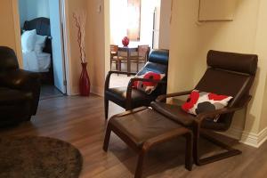 ein Wohnzimmer mit 2 Stühlen und einem Sofa in der Unterkunft 2-Bedroom Apartment Sweet #5 by Amazing Property Rentals in Gatineau