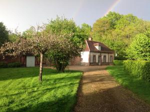 una casa con un árbol y un arco iris en el fondo en Le Rucher, en Bois-Normand-près-Lyre