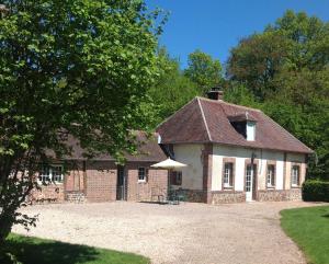 an old brick house with an umbrella in front of it at Le Rucher in Bois-Normand-près-Lyre