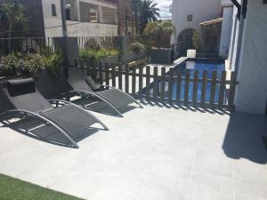 zwei Stühle auf einer Terrasse neben einem Zaun in der Unterkunft Villa Masnou Homelydays in El Carrer del Canonge + 4 Fotos