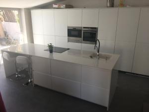 eine weiße Küche mit Arbeitsplatte und Spüle in der Unterkunft Villa Masnou Homelydays in El Carrer del Canonge