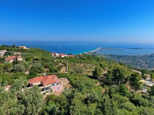 a house on a hill with the ocean in the background at Domus Nostos in Apolpaina