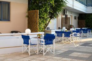 a row of chairs and tables with blue chairs at Balito in Kato Galatas
