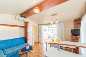 Mobile home Laguna في سفيتي بيتار: غرفة معيشة مع أريكة زرقاء وطاولة
